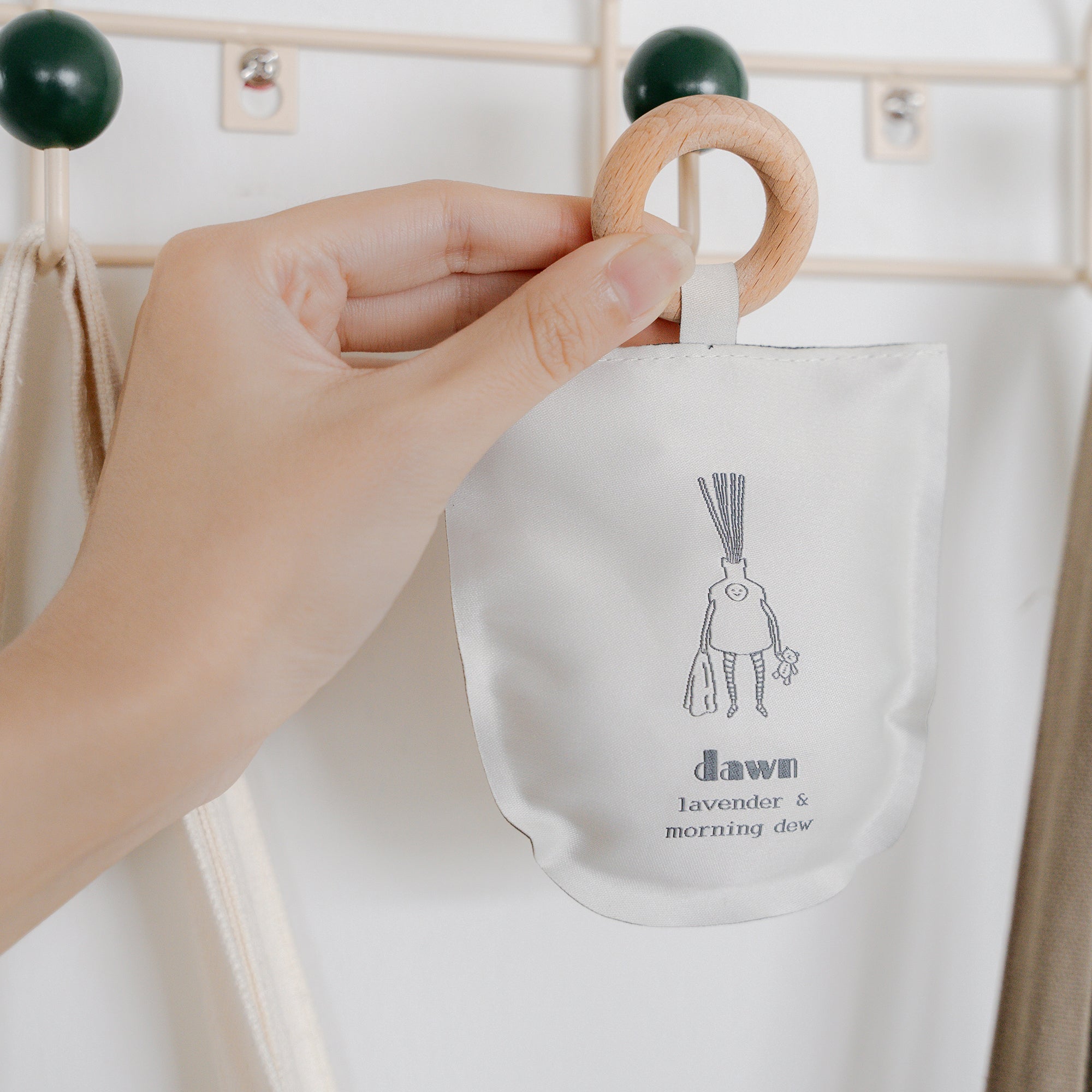 person hanging scented sachet with bag and clothes rack hanger